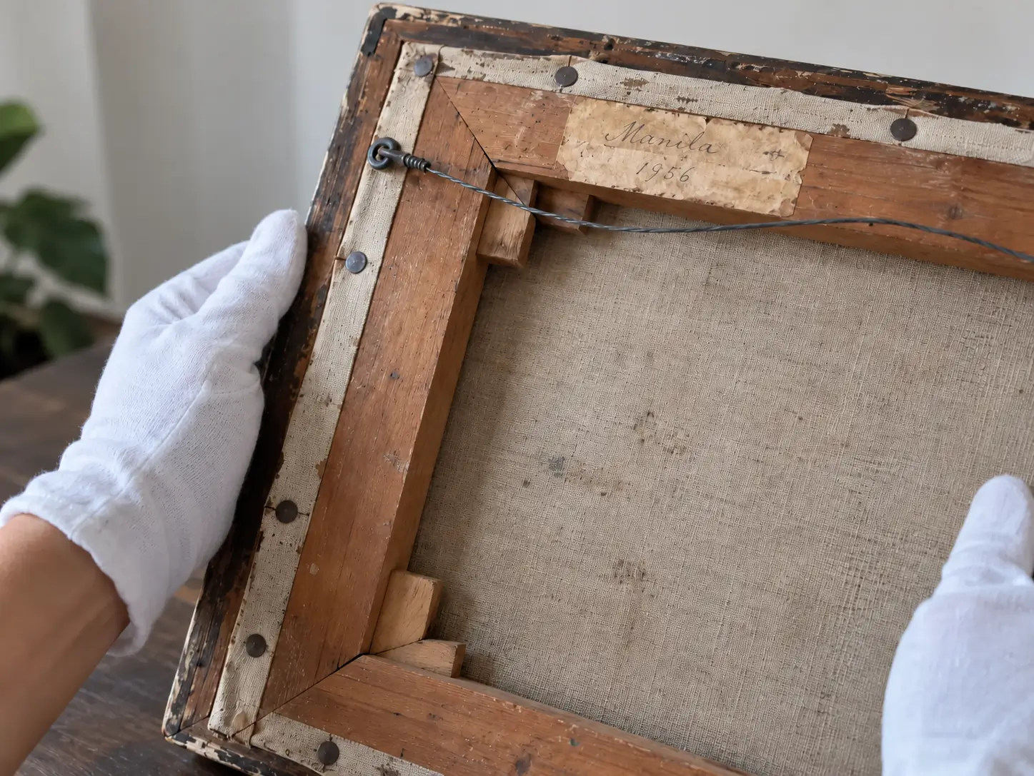 A collector examining the stretcher bars and canvas edge on the back of a painting